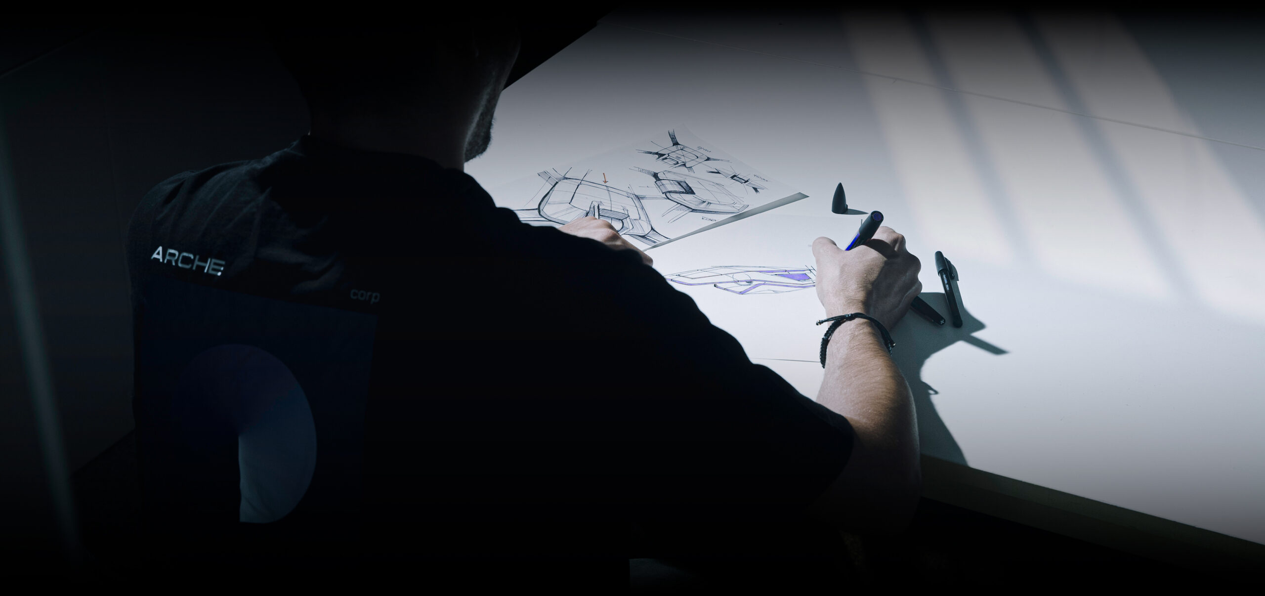 Designer du bureau d'étude ARCHE travaillant sur la conception d’un projet innovant, entre créativité et ingénierie.